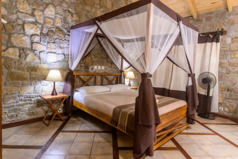 Chambre en pierre avec lit à baldaquin et moustiquaire, région de l'Isalo