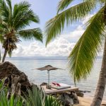 Plage bordée de cocotiers et transat face au lagon, Nosy Be